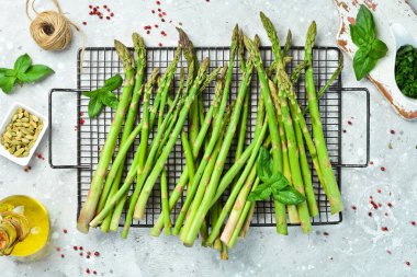 Taş zeminde taze kuşkonmaz pişiriyorum. Sağlıklı yiyecekler. Üst görünüm.