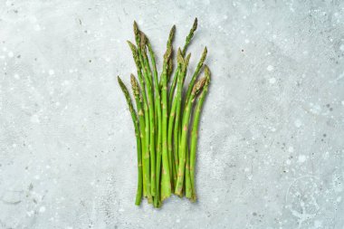 Taş zeminde taze yeşil kuşkonmaz var. Sağlıklı yiyecekler. Üst görünüm.