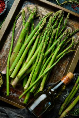 Kuşkonmaz pişiriyorum. Baharatlı yeşil kuşkonmaz. Sağlıklı yiyecekler. Taş zeminde. Üst görünüm.