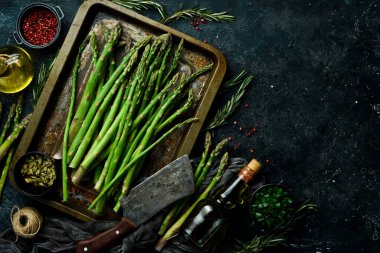 Kuşkonmaz pişiriyorum. Baharatlı yeşil kuşkonmaz. Sağlıklı yiyecekler. Taş zeminde. Üst görünüm.