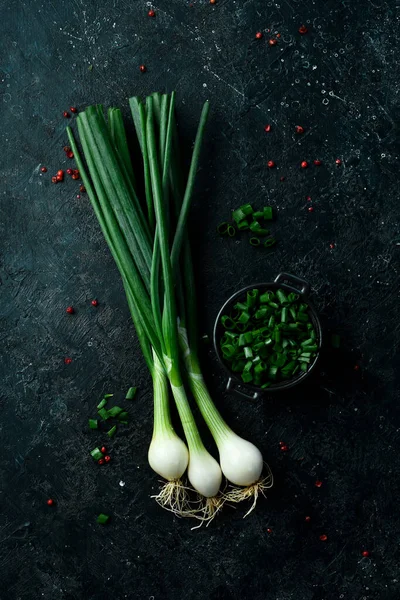 Siyah taşlı arka planda taze soğan. Sağlıklı yiyecekler. Üst görünüm.