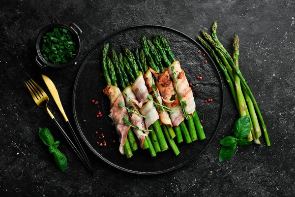 Pastırmayla sarılmış ızgara yeşil kuşkonmaz. Sağlıklı yiyecekler. Taş zeminde. Üst görünüm.