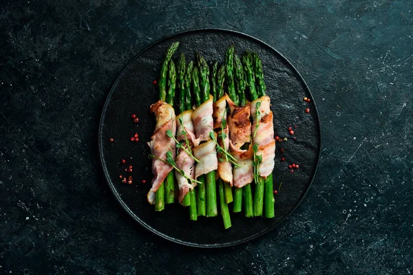 Pastırmayla sarılmış ızgara yeşil kuşkonmaz. Sağlıklı yiyecekler. Taş zeminde. Üst görünüm.