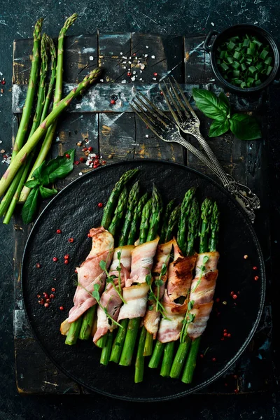 Pastırmayla sarılmış ızgara yeşil kuşkonmaz. Sağlıklı yiyecekler. Taş zeminde. Üst görünüm.