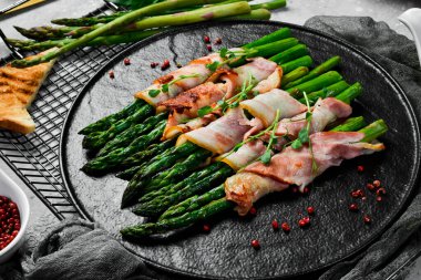 Pastırma ve fesleğenli ızgara kuşkonmaz. Taş zeminde. Üst görünüm.