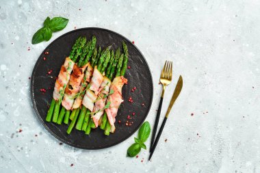 Pastırma ve fesleğenli ızgara kuşkonmaz. Taş zeminde. Üst görünüm.