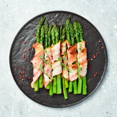 Pastırma ve fesleğenli ızgara kuşkonmaz. Taş zeminde. Üst görünüm.