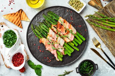 Pastırma ve fesleğenli ızgara kuşkonmaz. Taş zeminde. Üst görünüm.