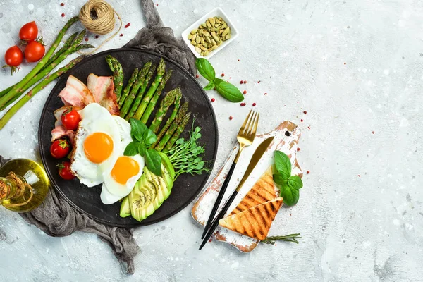 Frühstück Rührei Spargel Speck Und Avocado Auf Einer Schwarzen Steinplatte — Stockfoto
