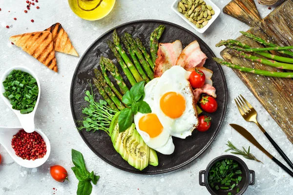 Kahvaltıda Çırpılmış Yumurta Kuşkonmaz Pastırma Avokado Siyah Taştan Bir Tabakta — Stok fotoğraf