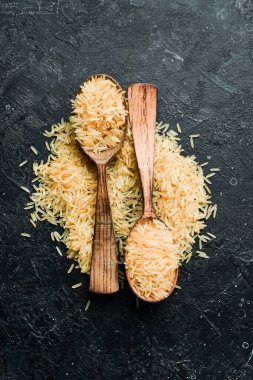 Pirinç ahşap bir kaşıkta inliyor. Taş bir arka planda. Sağlıklı yemek..