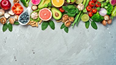 Karbonhidratsız sağlıklı yiyecekler. Taze brokoli, avokado, fındık, domates ve narenciye. Ketojenik diyet kavramı. Gri taştan bir arka planda. Üst görünüm.