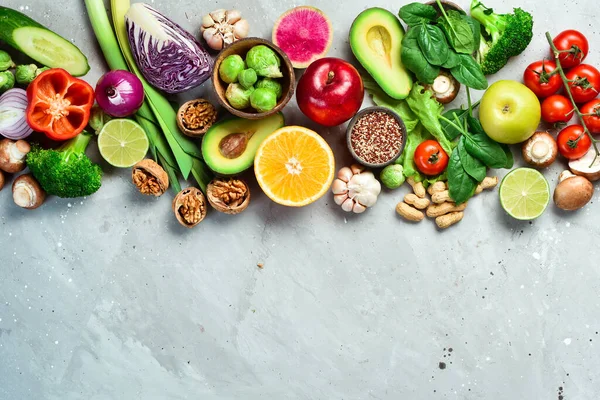 Vegan diet with a high content of dietary fiber and strengthens the immune system: fresh vegetables, fruits, nuts, mushrooms and berries. On a gray stone background. Top view.