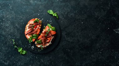 Peynirli sandviç, jambon, çilek ve fesleğen. Allah 'ım. Üst Manzara. Taş bir arka planda.