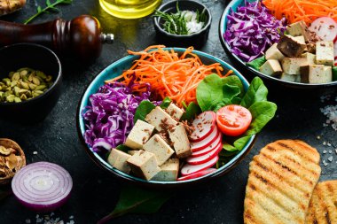 Tofu peyniri, ıspanak, lahana, turp ve havuçla detoks Buda kasesi. Beslenme konsepti. Taş bir arka planda.