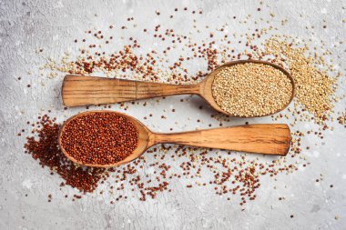 Ahşap mutfak masasında kaşıklarda karıştırılmış kinoa. Sağlıklı ve diyet süper gıda ürünü.