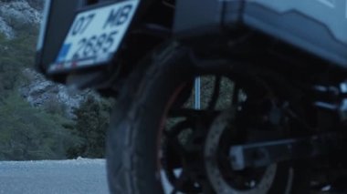 Motosikletli turist, modern motosikletle geri dönüyor.