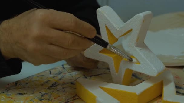 Primer plano de un anciano manos pintura y coloración en estrella amarilla — Vídeos de Stock