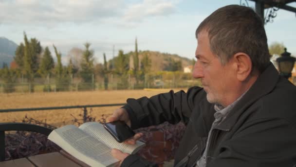 Erwachsener Mann liest und scannt kleines Buch — Stockvideo