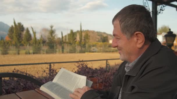 Smiling adult man reading book — Stock videók