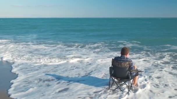 Człowiek czytanie książki na plaży — Wideo stockowe