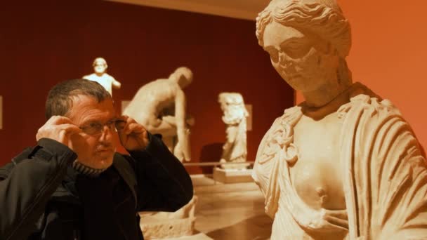 Uomo in occhiali da vista guardando la scultura — Video Stock