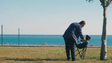 Sahilde bir adam ve sandalye