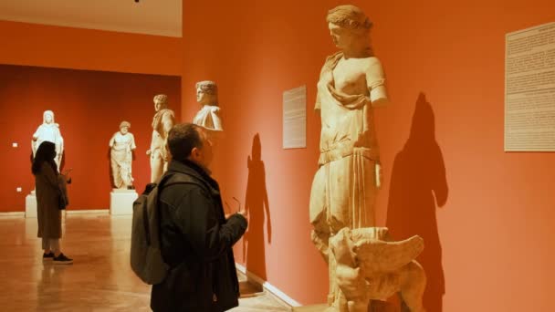 Mann betrachtet antike Frauenskulpturen — Stockvideo