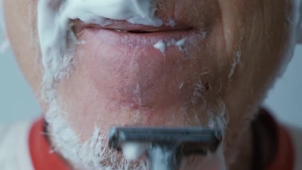 Przerażony człowiek krwawienia podczas golenia twarzy z ostrzem — Wideo stockowe