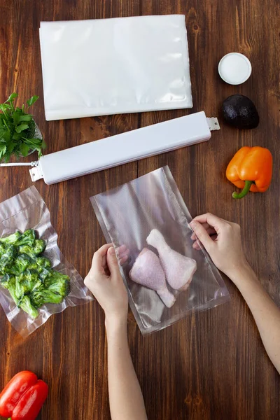 木製の暗いテーブルの上に野菜を詰め物の横に掃除機で真空包装やシールのための鶏の足を準備するプロセス スペーステキストのコピー — ストック写真