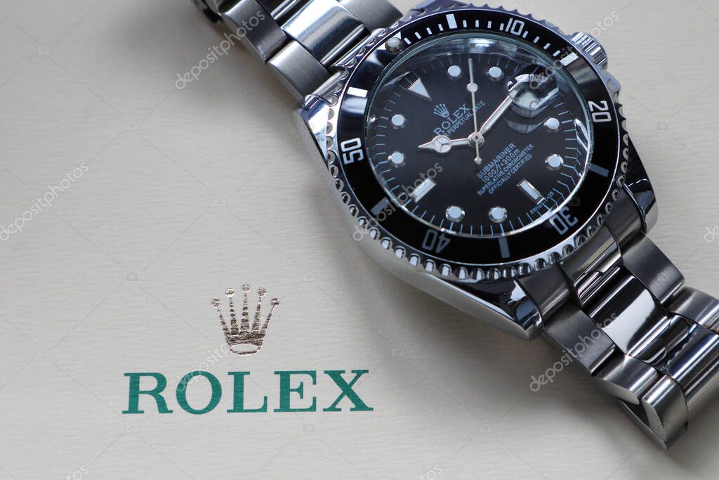 The Rolex vintage wristwatch ceramic bezel model black oyster perpetual submariner date 39 mm display on the ivory background of Rolex crown logo