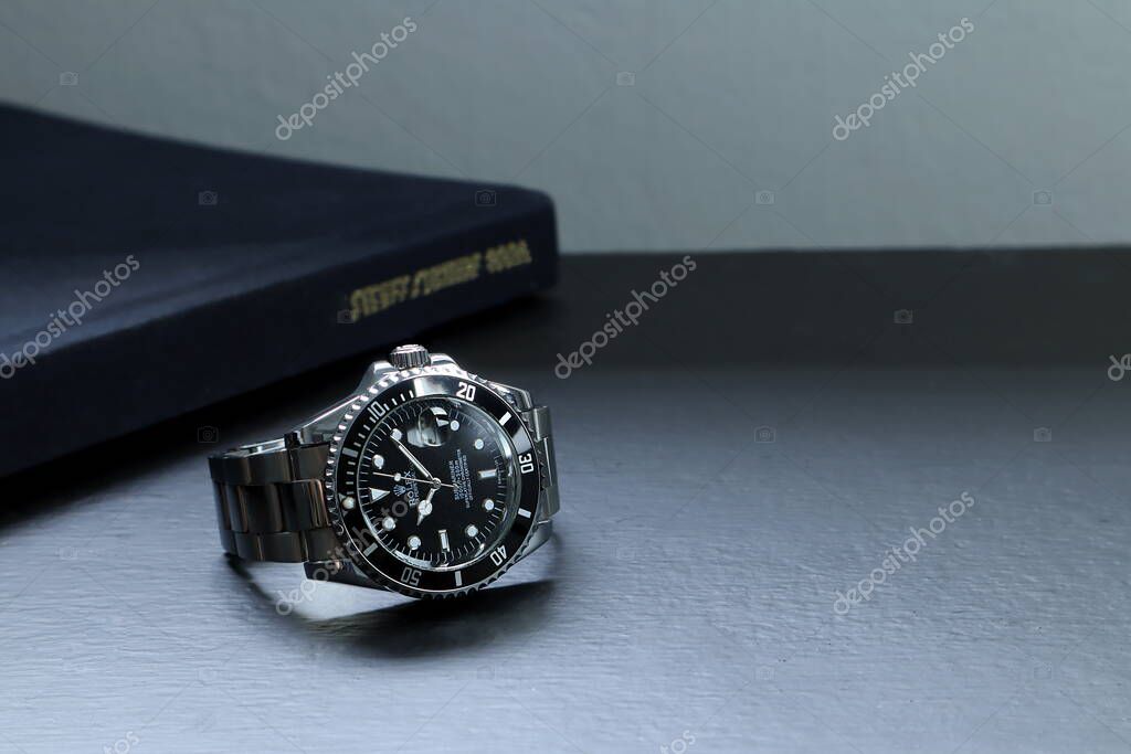 The Rolex vintage wristwatch ceramic bezel model black oyster perpetual submariner date 39 mm display on black table with dark black background in the luxury watch shop