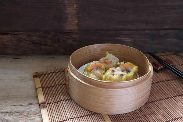 在中国餐馆的茶话会上 小虾水脉 饺子都在竹子蒸笼里 或者在中国餐馆的木制黑桌上 与密友共度新年 — 图库照片
