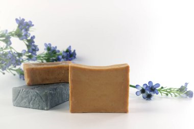 Doğal bitkisel el yapımı sabun, ahşap tepside tarçın çubukları, anason ve aromaterapi ürünleri dükkanında beyaz beton duvarın arka planına sahip çam kozalağı ile birlikte. 
