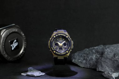 Altın Casio G Şok sporu dayanıklı ve suya dayanıklı kol saati Shinjuku 'daki saat dükkanının siyah taş rafında sergileniyor.