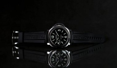 Panerai ya da Pam model 005 markası, Panerai mağazasındaki yetkili satıcıda siyah arka planlı siyah cam masa rafında sergilenmektedir.