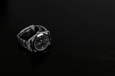 Rolex klasik kol saati modeli istiridye daimi kaşif I 39 mm siyah ahşap masa üzerinde lüks saat sergisi