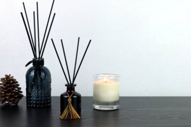 Birçok lüks aroma aromalı difüzyon şişesi ahşap masa üzerinde kokulu mum ile romantik oluşturmak ve yatak odasındaki ortamı gevşetmek için Sevgililer Günü 'nde beyaz çimento duvarlı arka plan