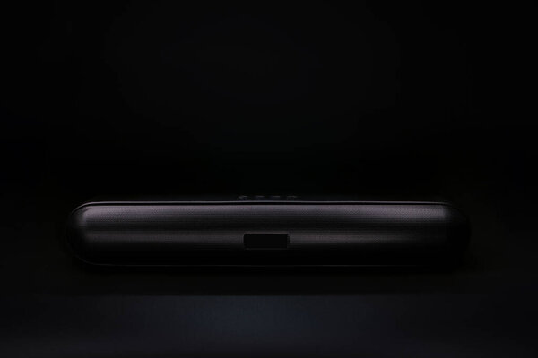 modern design wireless bluetooth speaker or sound bar is on the black table with black wall in the black studio during playing the movie