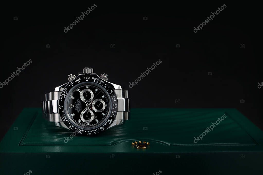 Rolex wristwatch model cosmograph daytona oyster perpetual superlative chronometer with black ceramic bezel stainless steel body is on Rolex green box crown logo package with black wall background
