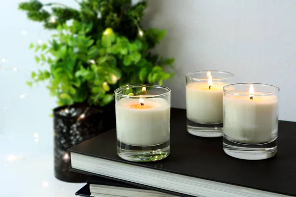 Luxusní Osvětlení Aromatické Voňavé Skleněné Svíčky Několik Knih Jsou Bílém — Stock fotografie