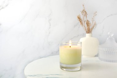 Sevgililer gününde beyaz mermer duvarlı beyaz yatak odasındaki ortamı yumuşatmak ve romantik bir ortam yaratmak için beyaz renkli kokulu mum üzerine dekore edilir.