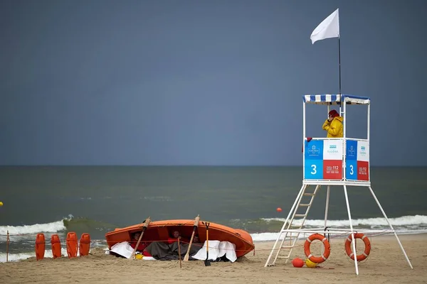 lifeguards hide in the lifeboat during a storm on the beach