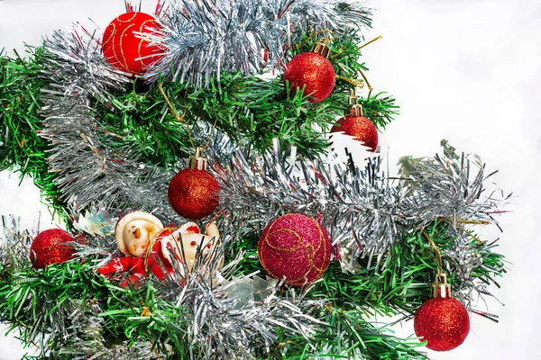 赤いボールとノエルの姿をした銀のガーランドを持つクリスマスツリーのクローズアップ 白い背景の上に — ストック写真