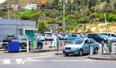 Güneşli bir günde modern bir benzin istasyonunda elektrikli araba şarj ediliyor.