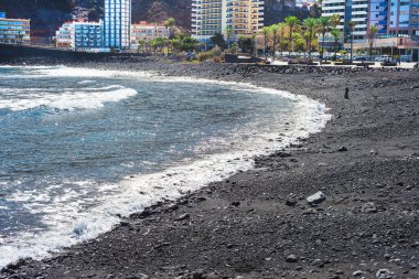 Puerto de la Cruz 'da güneşli bir günde siyah taşlar plajı. İspanya