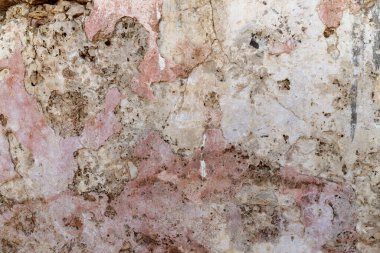 Eski, yıkık dökük taş bir duvar. Kaya yüzeyinde çatlaklar var. Yakın plan..