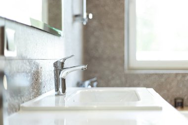 Krom musluğu olan modern lavabo (su karıştırıcı) yakın plan.