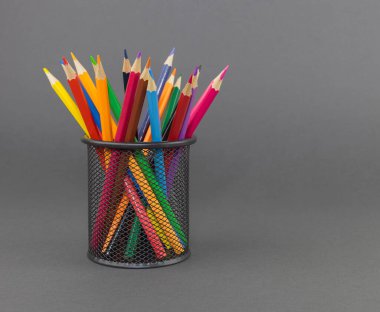 Gri arkaplanda siyah kalem tutacağında renkli kalemler