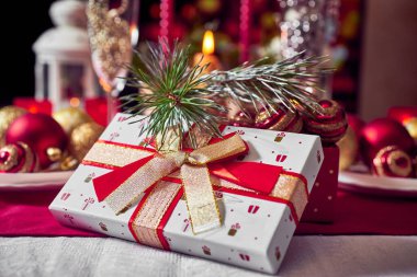 Kırmızı mumlar, ışıklar, altın toplar, masada Noel süsleri. Yakın çekim, seçici odaklanma.